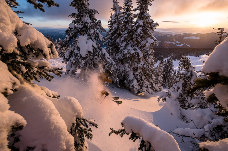 5d839c9b01799 A skier gliding through fresh powder during a sunset at Sun Peaks Resort Destination BC Reuben Krabbe min