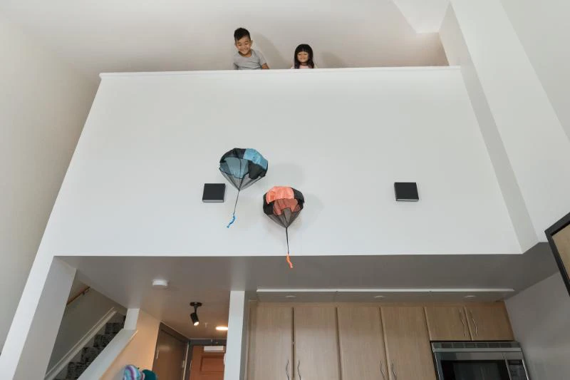 601a85205bef8 Kids Throwing Parachutes in Loft