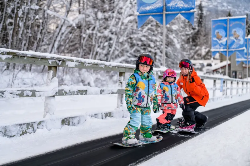 64661d62e5428 Young child snowboarding with instructor Cordilleran Creative Inc