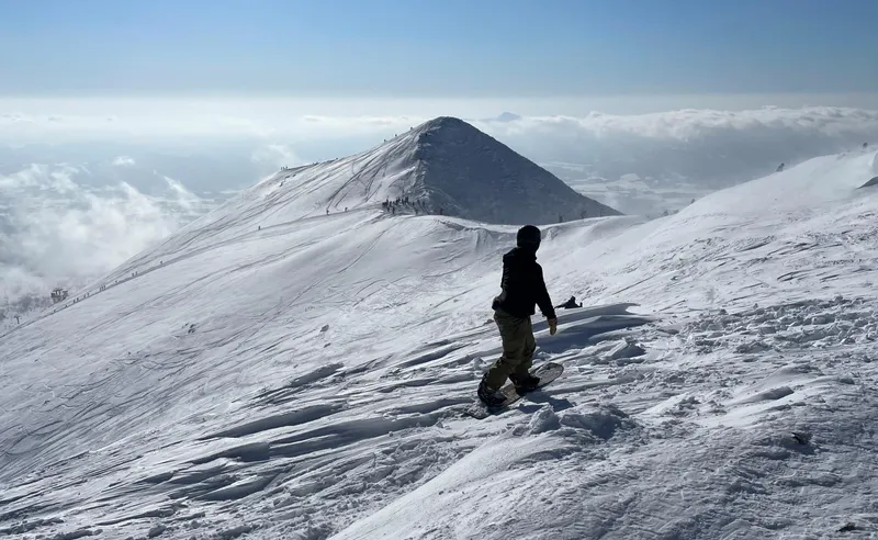 Snowboarder and distant slopes, Niesko, Japan - Nicholas Farnell - January 2023