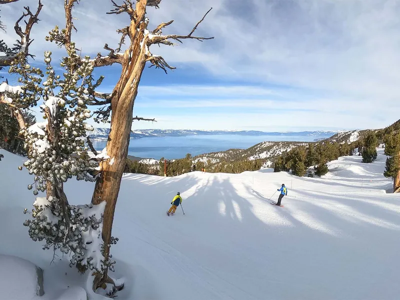Skiers facing views across Tahoe - Heavenly, USA © Ficeto, Vail Resorts