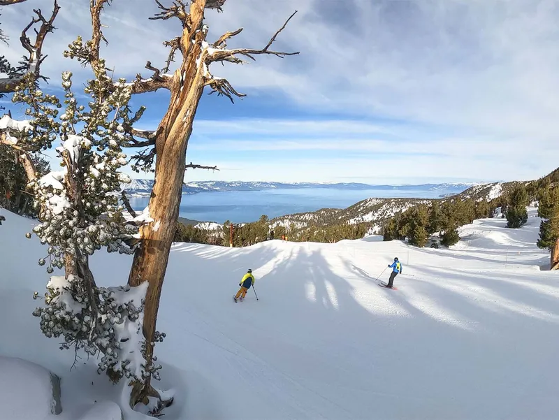 Skiers facing views across Tahoe - Heavenly, USA © Ficeto, Vail Resorts