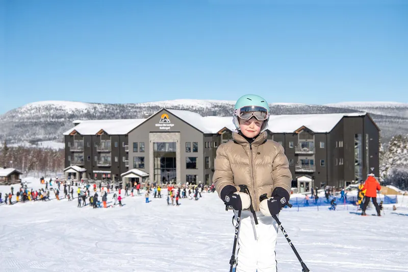 Ski Lodge Soltorget - Child smiles outside building © Stoen.se