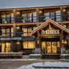 A snowy hotel exterior and café illuminated by its window light