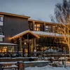 A snowy restaurant exterior in the fading light, illuminated by its windows and fairylights
