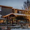 A snowy restaurant exterior in the fading light, illuminated by its windows and fairylights