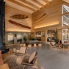 Bright, airy hotel lobby with lounge chairs and restaurant entrance