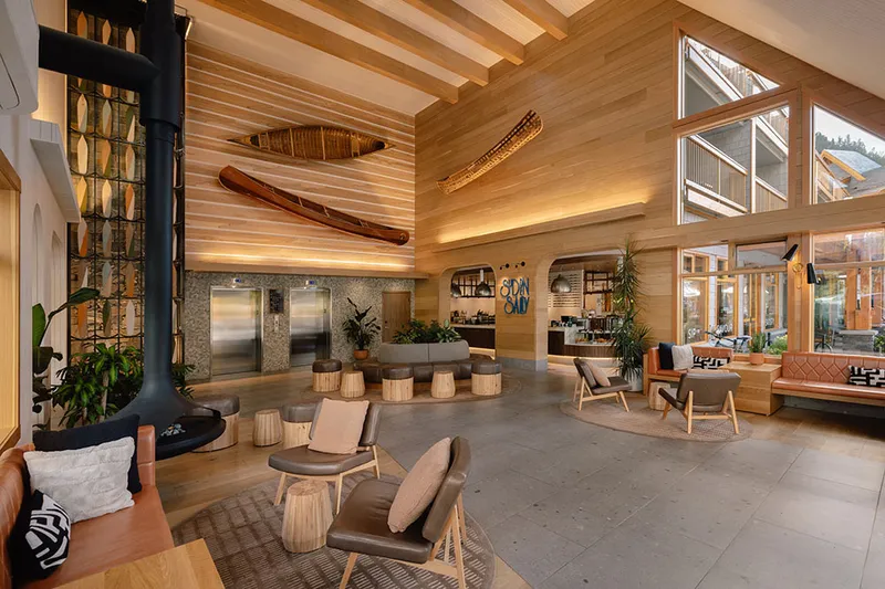 Bright, airy hotel lobby with lounge chairs and restaurant entrance