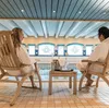 Couple relaxing in deckchairs beside the pool inside Fleischer's Hotel