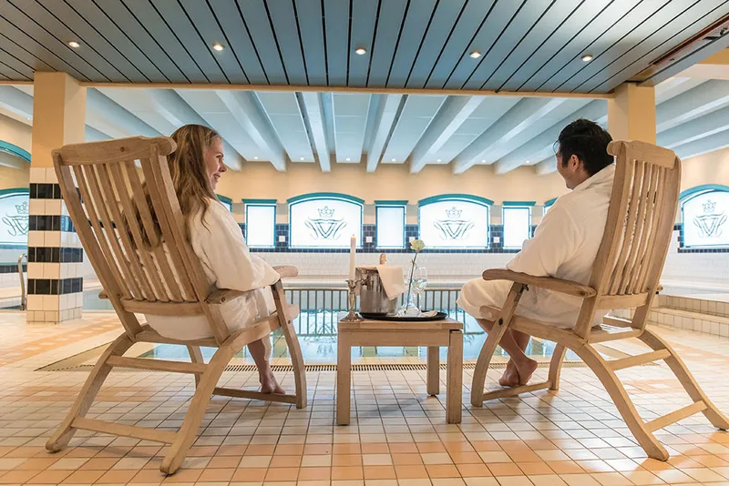 Couple relaxing in deckchairs beside the pool inside Fleischer's Hotel