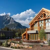 Detail of The Otter Hotel's wood and glass exterior with a mountain backdrop